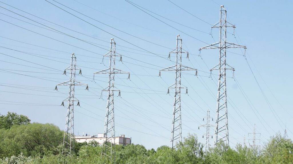 Electric transmission towers and power lines against a blue sky